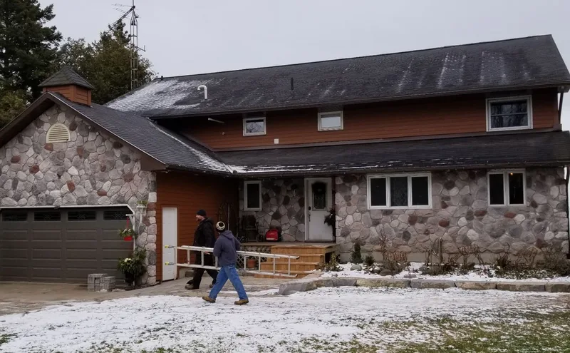 Stone-front home with brown siding and white exterior trim